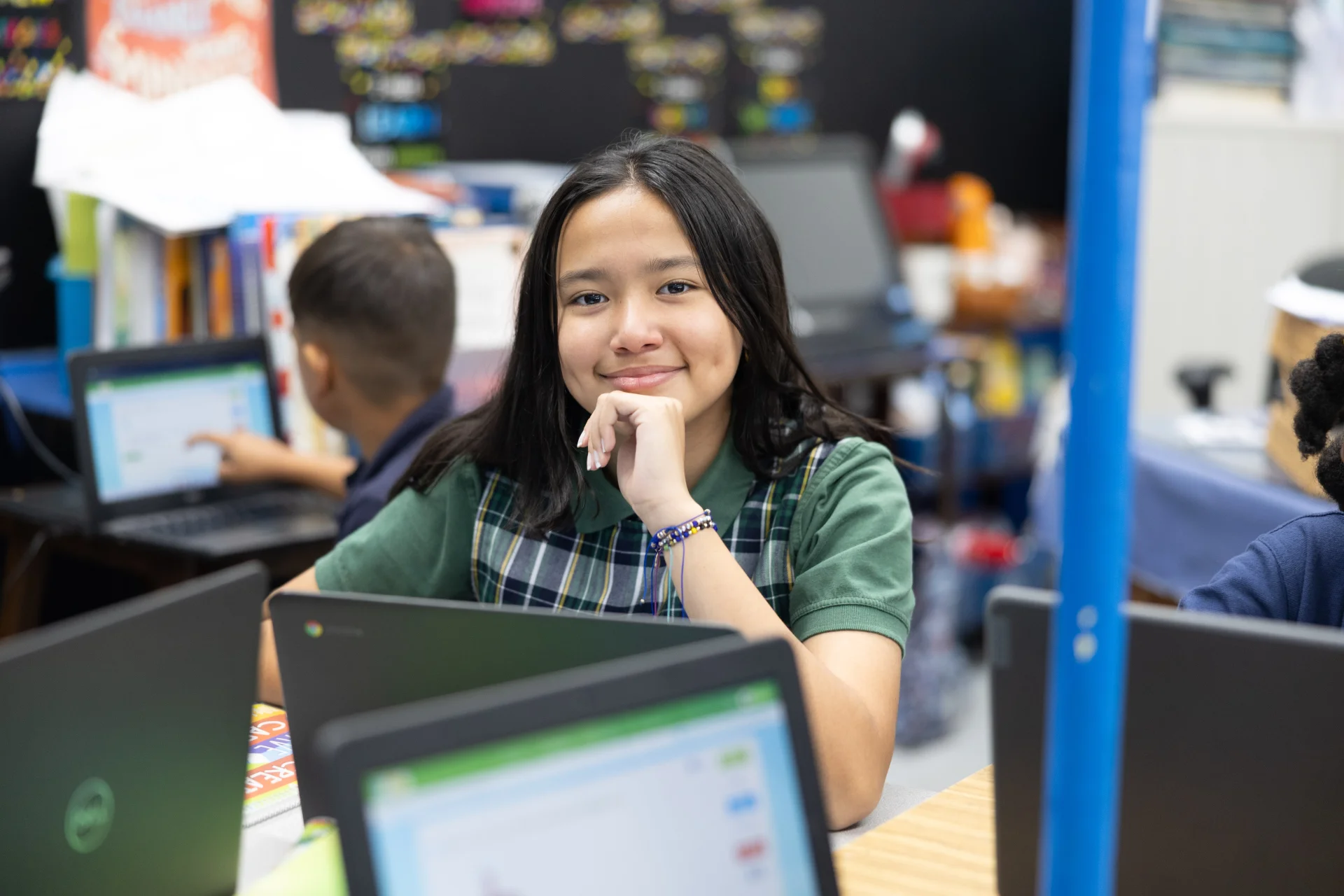 student smiling while working on laptop